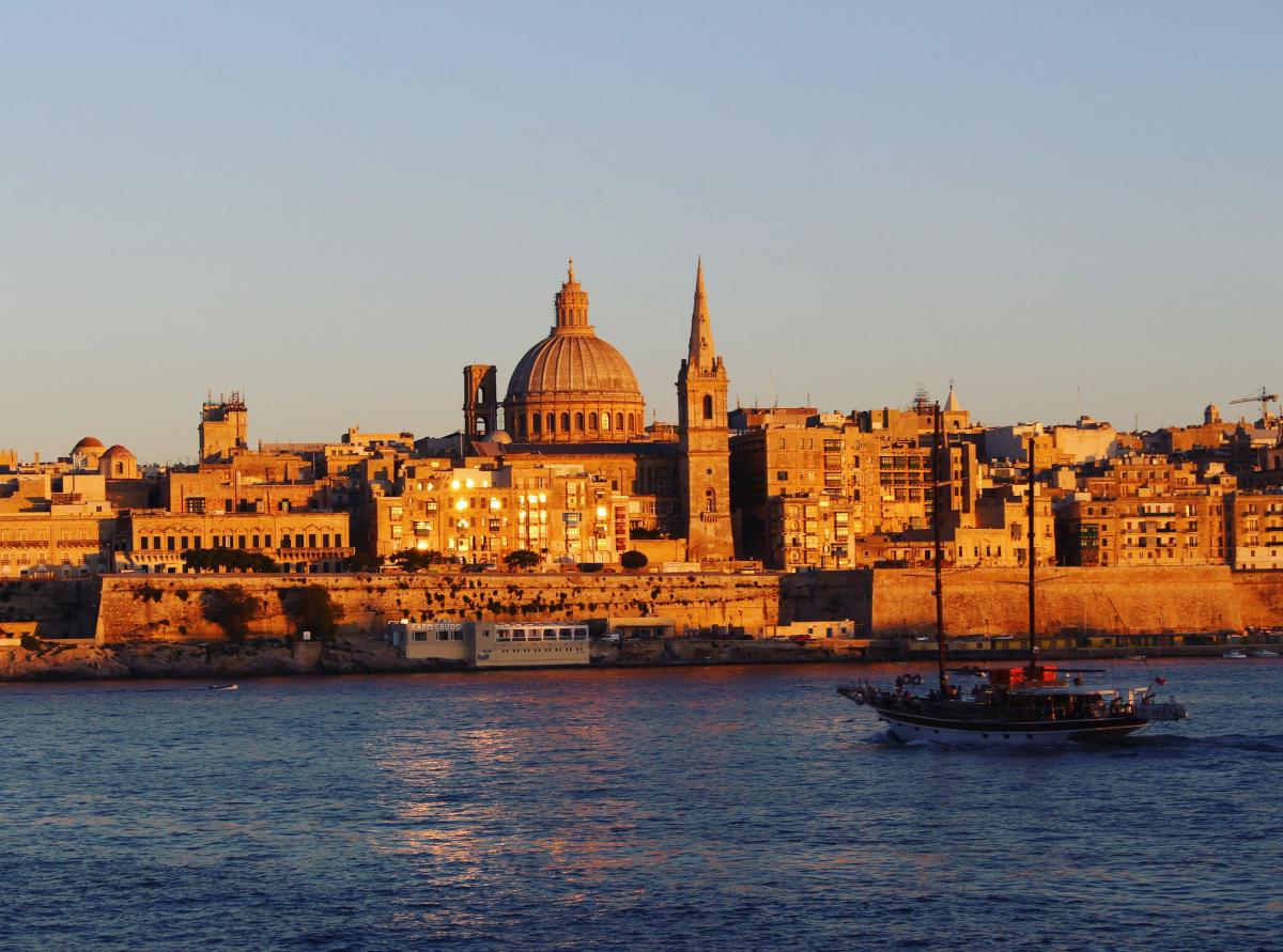 $Guide to obtaining Malta Permanent Residency on table